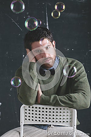 Stressed teacher man wearing stylish clothes in front a blackboard.