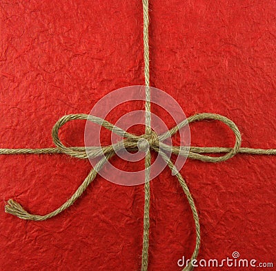 String tied in a bow on red paper