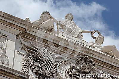 Stucco molding on the top part of a facade of the building against the sky with clouds in Lisbon, Portugal