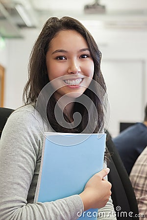 Student in a computer room holding a folder