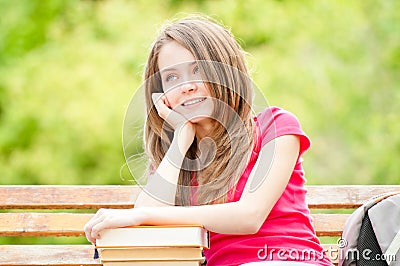 Student girl on bench with books and dreaming