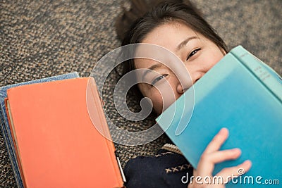 Student laying on carpet with books