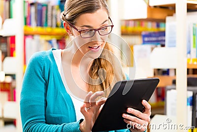 Student in library learning with tablet computer