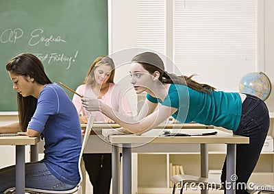 Student Tapping Classmate In Classroom 