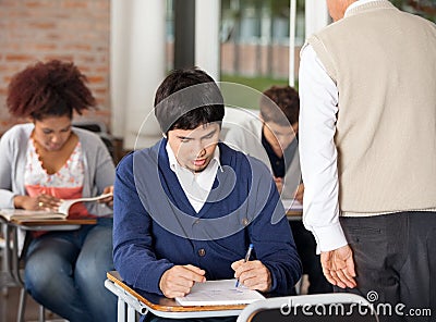 Students Giving Exam While Teacher Supervising