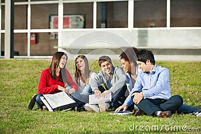 Students Sitting Together On Grass At University