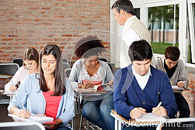 Students Writing Exam While Teacher Supervising