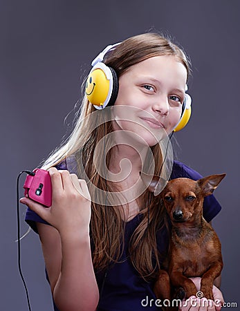 Studio shot of a smiling teen girl with headphones and doggy