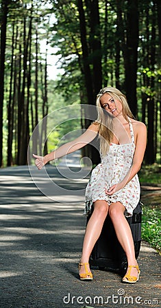 Stunning young blonde woman in sundress - hitching