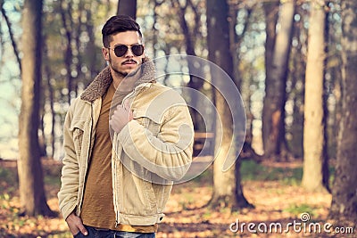 Stylish man posing in autumn park