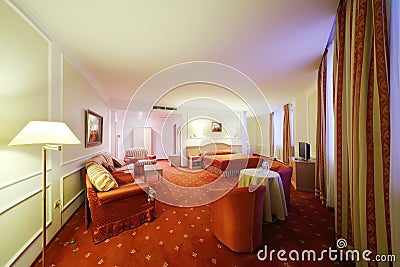 Stylish room with double bed with red linen, red couch