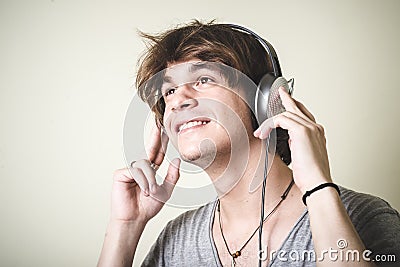 Stylish young blonde hipster man listening to music