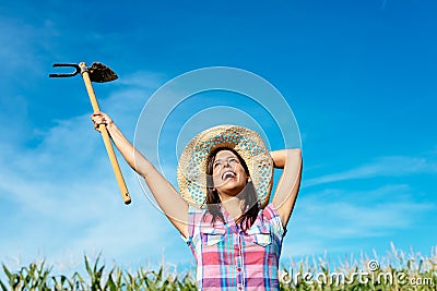 Successful female farmer raising hoe