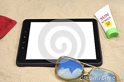 Summer background with digital tablet on the sand.