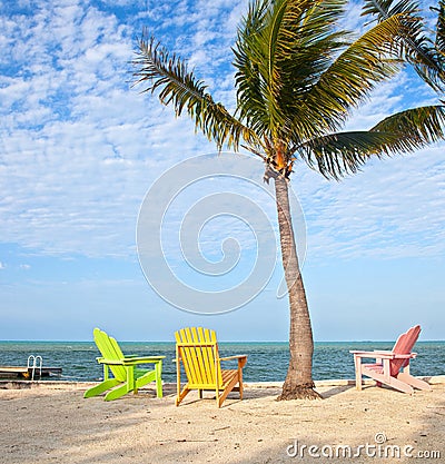 Summer beach scene with palm trees and lounge chairs