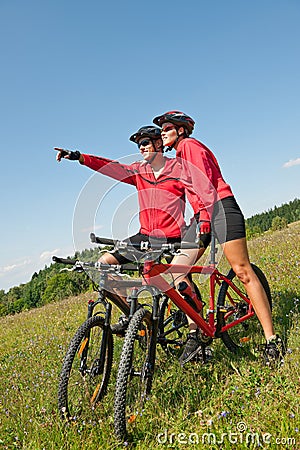 Summer bike - Young sportive couple in meadow