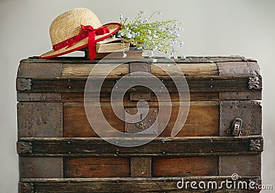 Summer blue flowers, old books and straw hat on vintage chest