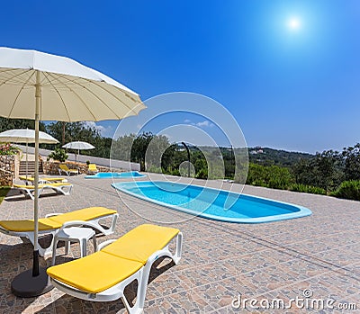 Summer pool with garden and sun loungers.