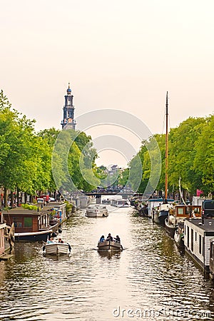 Summer view of an Amsterdam canal with people relaxing in small