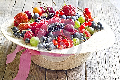 Summer wild berry fruits in the hat concept