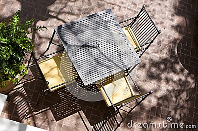 Sun drenched table for three at an outdoor cafe fr