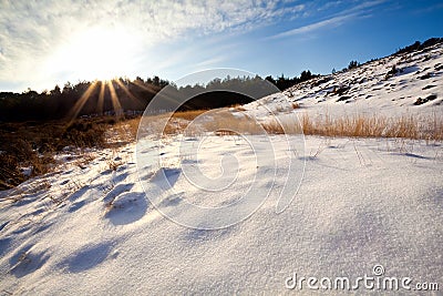 Sunbeams over snow hills