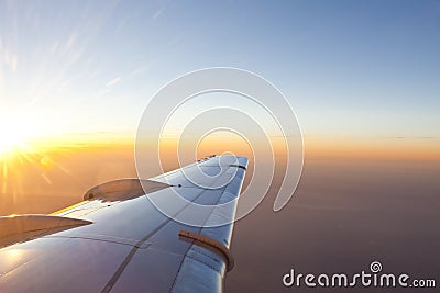 Sunset above wing of an airplane with Romantic sky