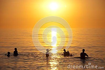 Sunset over ocean swimmers