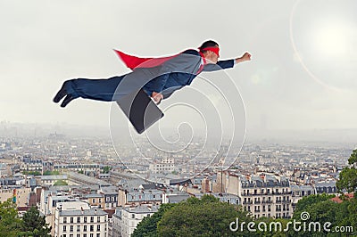 Superhero businessman flying above a city