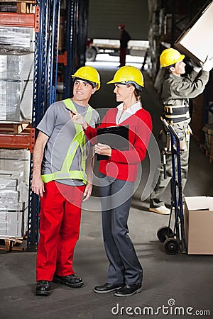 Supervisor Instructing Foreman At Warehouse