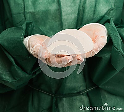 Surgeon hands with silicon breast implant