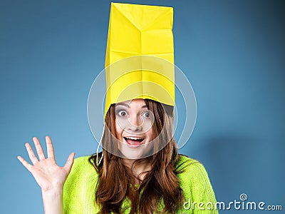 Surprised girl paper shopping bag on head. Sales.