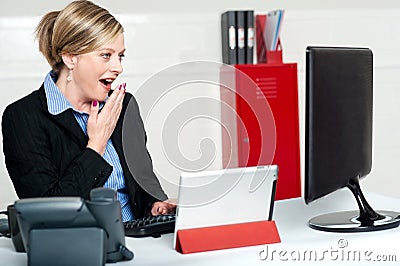 Surprised female secretary looking at lcd screen