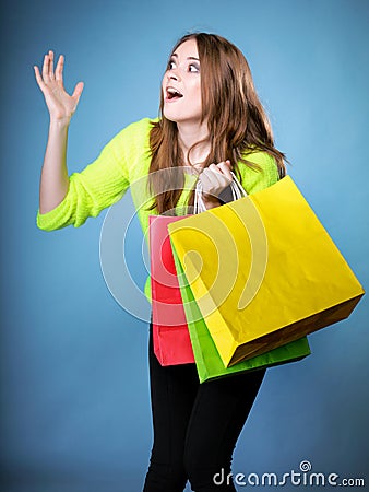 Surprised girl with paper shopping bag. Sales.