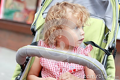 Surprised girl in the pram.