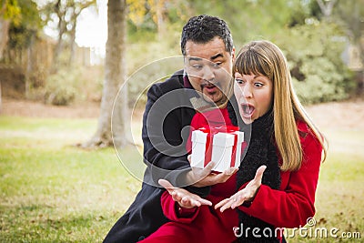 Surprised Mixed Race Couple Giving Gifts