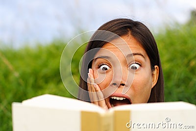 Surprised woman reading book
