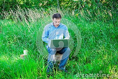 Surprised Young man outdoors with a cup and laptop