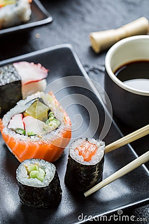 Sushi on black ceramic eaten with chopsticks
