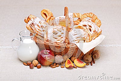 Sweet cakes in basket, fruit and milk decoration