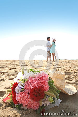 Sweet couple on the beach with bouquet