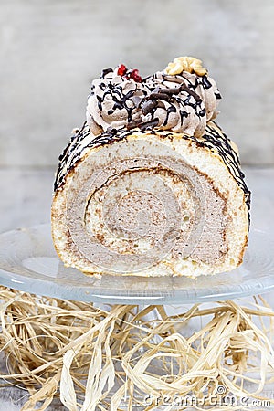 Sweet roll cake on transparent glass cake stand