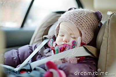 Sweet toddler girl sleeping in a car seat