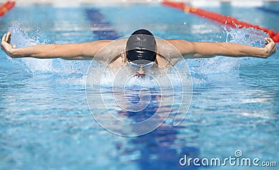 Swimmer in cap breathing performing the butterfly stroke