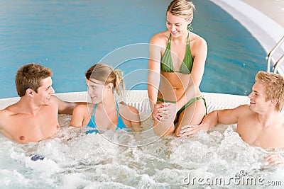 Swimming pool - happy people relax in hot tub
