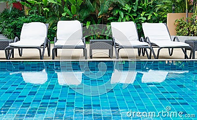 Swimming pool with white beach chairs