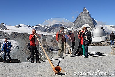 Swiss man blowing traditional alpine horn