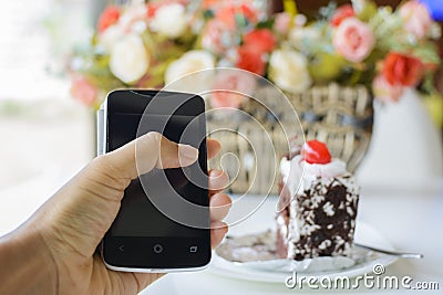 Tablet with chocolate cake on a table
