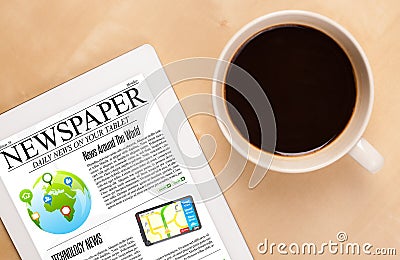 Tablet pc shows news on screen with a cup of coffee on a desk