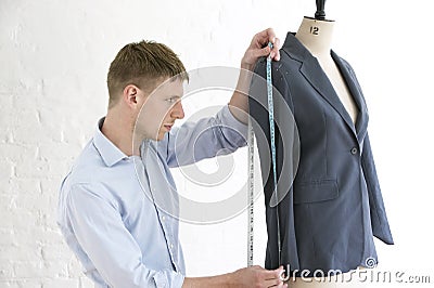 Tailor Measuring Suit On Mannequin In Studio